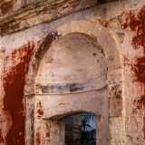 Le pareti, ormai scrostate, mostrano in alcuni punti il loro originale color rosso acceso